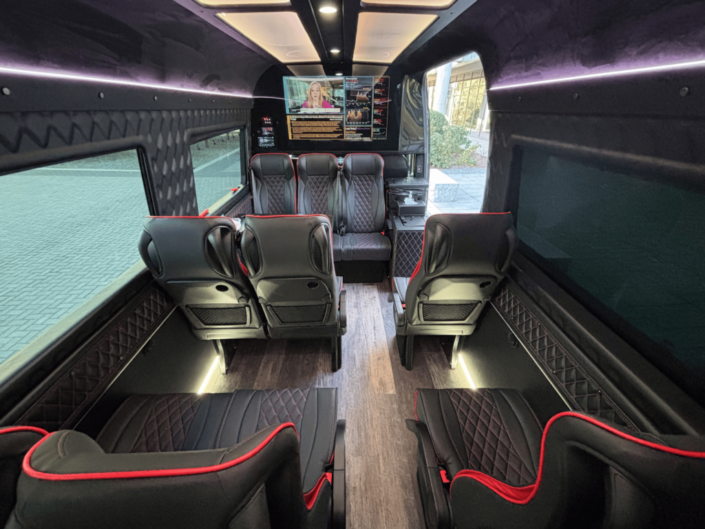 Interior of Duke Limo luxury Sprinter van used for Charlotte airport transportation with captain chairs and TV