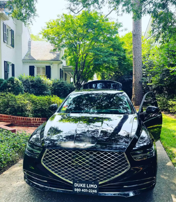 Luxury black sedan from Duke Limo parked outside an upscale home in Charlotte, NC, ready for executive private transportation service.