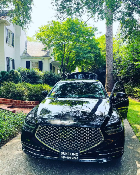 Elegant black limousine from Duke Limo parked in front of a luxurious mansion, ready for premium wedding transportation in Charlotte, NC