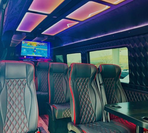 Luxury Sprinter van interior by Duke Limo with LED ceiling lights, leather captain’s chairs, and onboard TV – ideal for business and upscale group travel.
